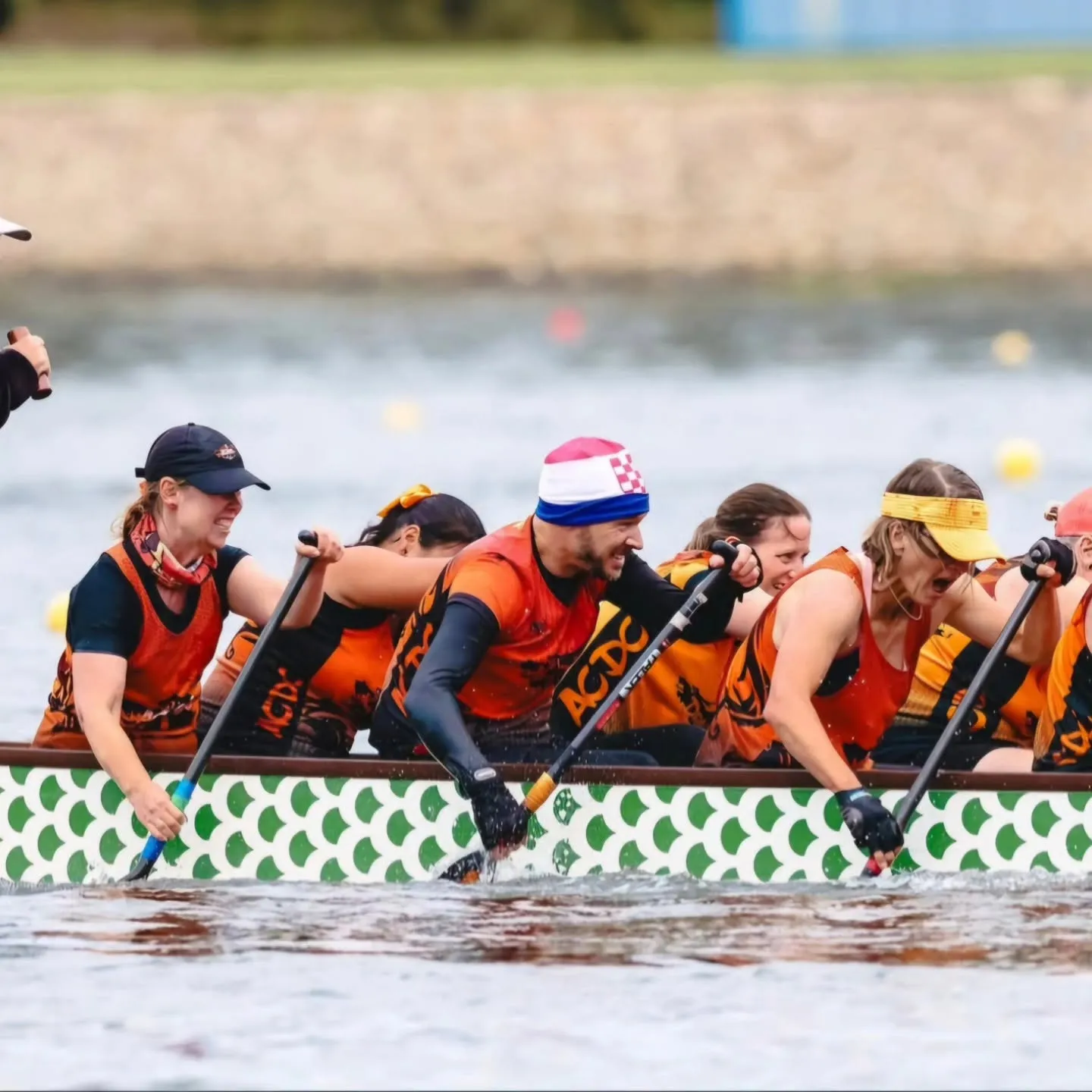 ACDC paddlers in orange race singlets digging in mid-race