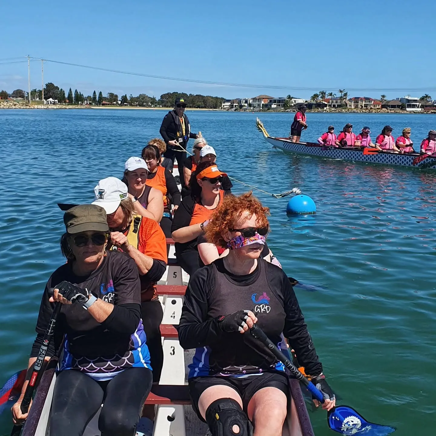 Smiling paddlers in the boat on a bright blue day